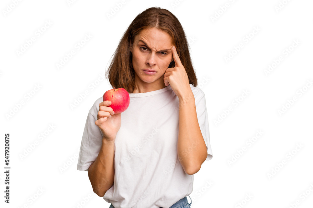 Young caucasian woman holding a red apple isolated pointing temple with finger, thinking, focused on a task. Young caucasian woman holding a red apple isolated pointing temple with finger, thinking, focused on a task.