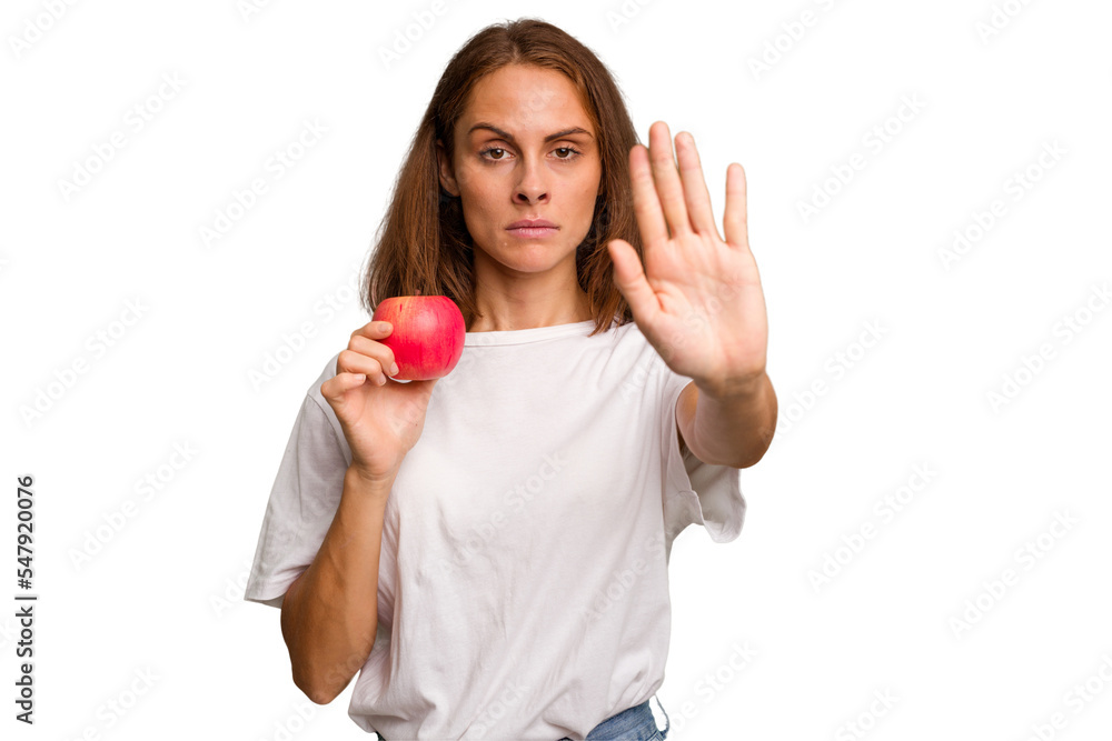 Young caucasian woman holding a red apple isolated standing with outstretched hand showing stop sign, preventing you. Young caucasian woman holding a red apple isolated standing with outstretched hand showing stop sign, preventing you.