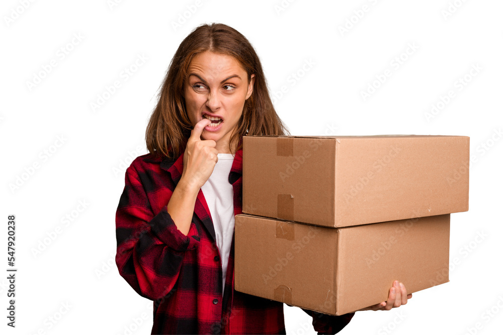 Young caucasian woman moving while picking up a box full of things isolated relaxed thinking about something looking at a copy space. Young caucasian woman moving while picking up a box full of things isolated relaxed thinking about something looking at a copy space.