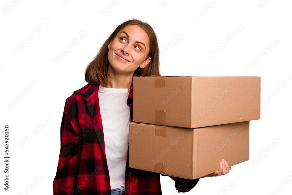 Young caucasian woman moving while picking up a box full of things isolated dreaming of achieving goals and purposes Young caucasian woman moving while picking up a box full of things isolated dreaming of achieving goals and purposes