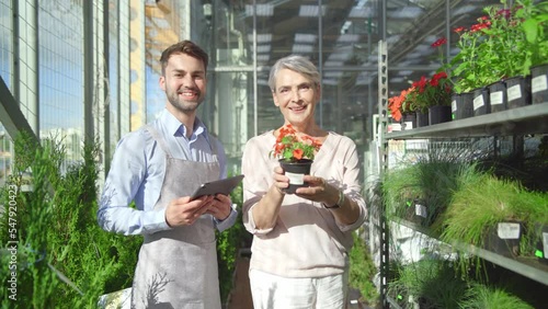 florist seller discussing a beautiful flower with a female guest.