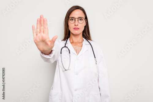 Young doctor woman isolated on white background standing with outstretched hand showing stop sign  preventing you.