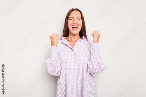 Young caucasian cute woman isolated on white background cheering carefree and excited. Victory concept.