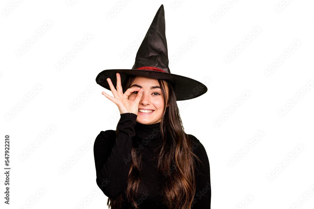 Young caucasian woman dressed as a witch isolated on green chroma background excited keeping ok gesture on eye. Young caucasian woman dressed as a witch isolated on green chroma background excited keeping ok gesture on eye.