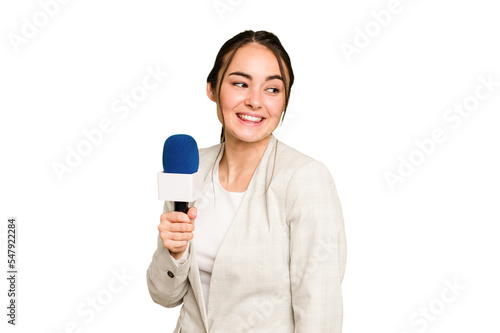 Young TV presenter caucasian woman isolated on green chroma background looks aside smiling, cheerful and pleasant.