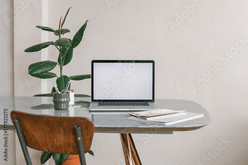 Office workplace. Blank laptop screen mockup on the table. Modern workplace. Minimal style. Copy space.