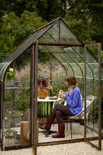 Woman relaxing in glasshouse in garden © rh2010