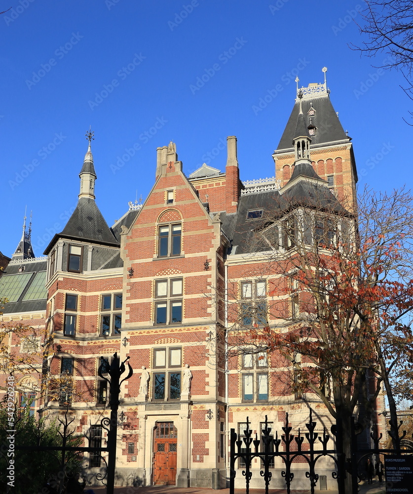 Amsterdam Rijksmuseum Building Exterior Detail with Bright Blue Sky and Autumn Tree, Netherlands