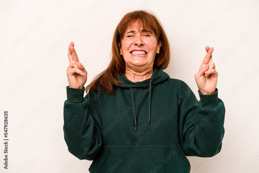 Middle age caucasian woman isolated on white background crossing fingers for having luck Middle age caucasian woman isolated on white background crossing fingers for having luck
