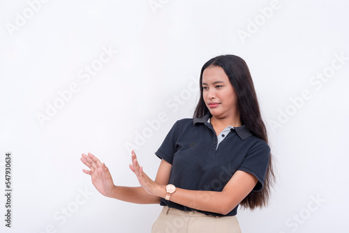 An unwilling woman shunning and keeping her distance from the left area. Using her hands to gesture to stop. Avoiding and steering clear of someone.