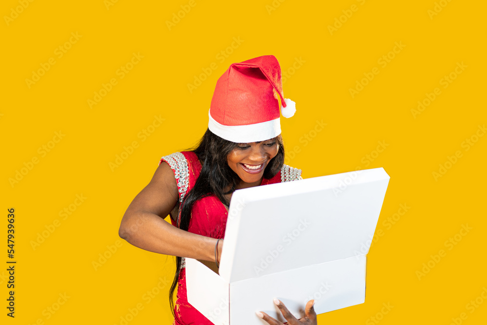 giovane ragazza nera che apre il regalo di natale sullo sfondo giallo giovane ragazza nera che apre il regalo di natale sullo sfondo giallo