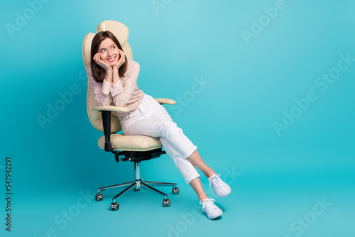 Full body size photo of young lady sitting wear pink shirt comfortable touch cheeks looking empty space company results isolated on blue color background