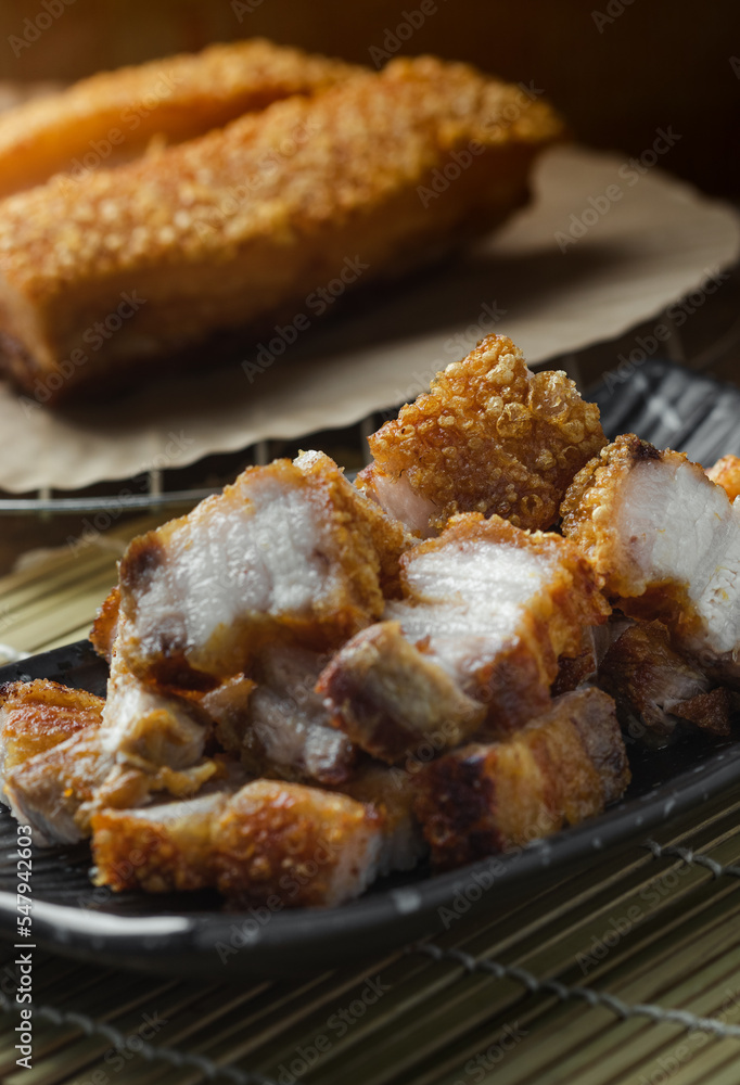 crispy pork belly deep fried pork or Chinese roasted pork belly on a wooden chopping board. close-up shot crispy pork belly deep fried pork or Chinese roasted pork belly on a wooden chopping board. close-up shot