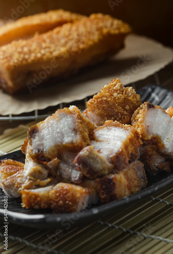 crispy pork belly deep fried pork or Chinese roasted pork belly on a wooden chopping board. close-up shot