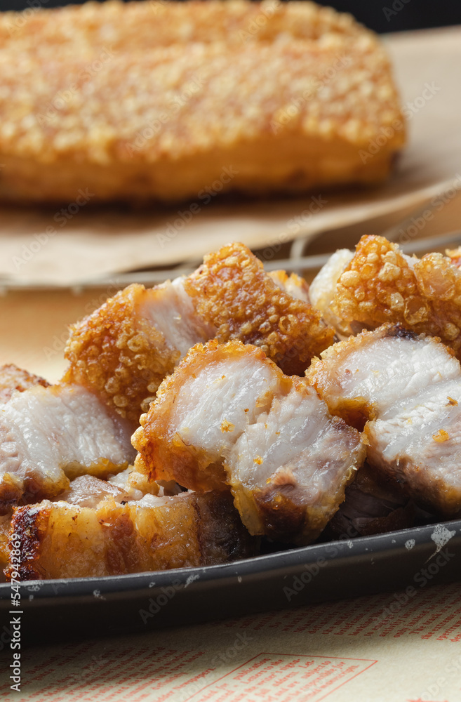 crispy pork belly deep fried pork or Chinese roasted pork belly on a wooden chopping board. close-up shot crispy pork belly deep fried pork or Chinese roasted pork belly on a wooden chopping board. close-up shot
