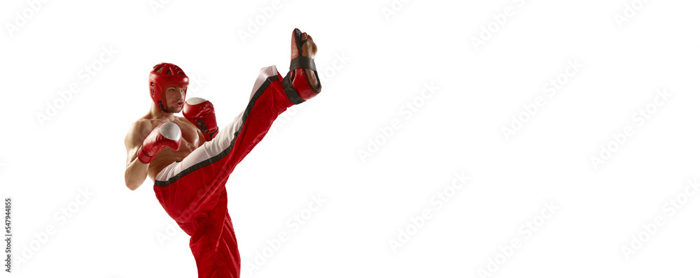 Young professional kickboxer wearing helmet and boxing gloves in motion isolated on white background. Sport, competition, energy, combat sports. Flyer Young professional kickboxer wearing helmet and boxing gloves in motion isolated on white background. Sport, competition, energy, combat sports. Flyer