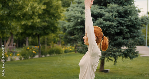 Fermale practises yoga in park. Concept of fitness, healthy lifestyle. Outdoor training. Cucasian woman stretch muscles, tendons. Yoga meditations. © RecCameraStock