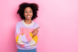 Photo of toothy beaming optimistic girl with perming coiffure wear knit sweater indicating empty space isolated on pink color background