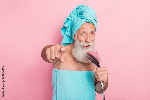 Photo of funky retired man sing shower head in bath point finger in camera isolated on pastel color background photo