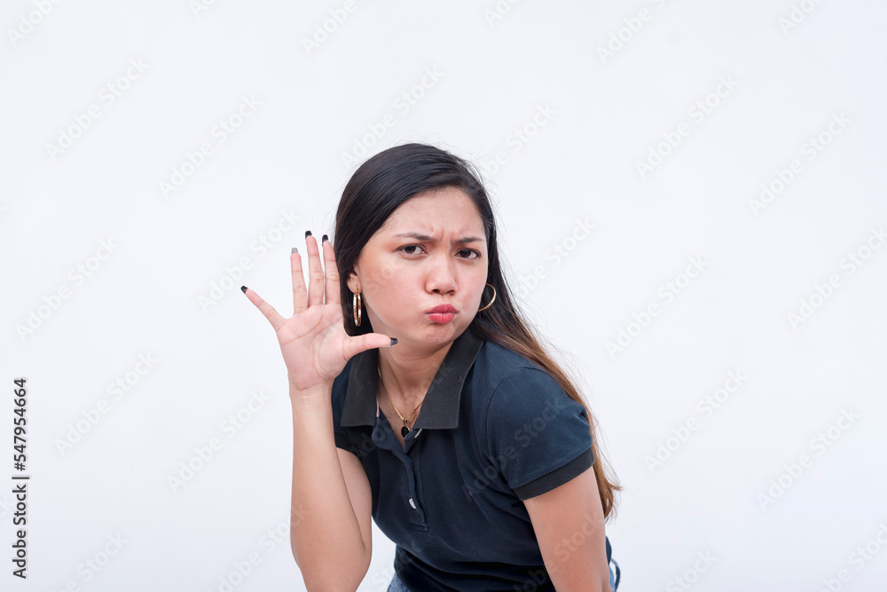 A young woman in disbelief and doubt while listening in to some wild and unsubstantiated rumors. Bending to the left, hands on her ear. Isolated on a white background. A young woman in disbelief and doubt while listening in to some wild and unsubstantiated rumors. Bending to the left, hands on her ear. Isolated on a white background.