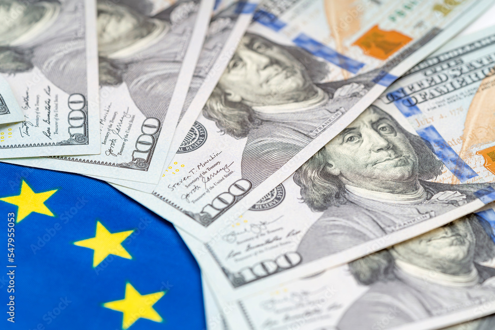 US dollar bills against background of EU flag. Financial condition of residents of European Union, taxes, loans, mortgages. State debt of country US dollar bills against background of EU flag. Financial condition of residents of European Union, taxes, loans, mortgages. State debt of country