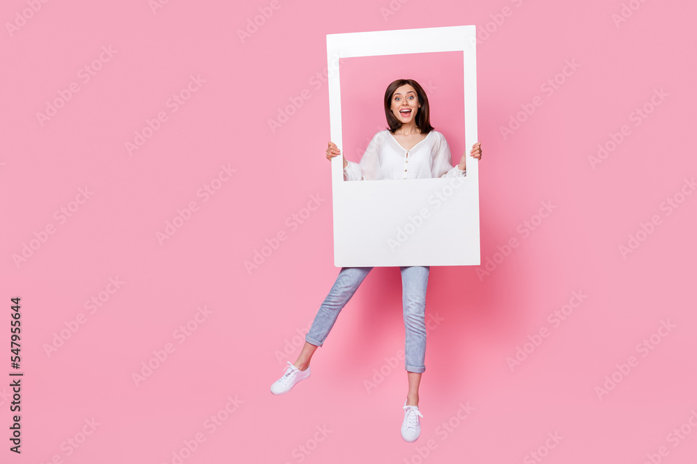 Full length photo of overjoyed lady hand hold white cadre picture hobby rejoice enjoy empty space isolated on pink color background Full length photo of overjoyed lady hand hold white cadre picture hobby rejoice enjoy empty space isolated on pink color background