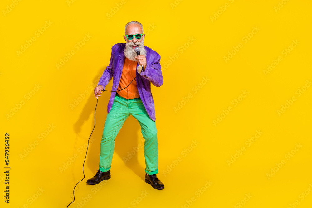 Full length photo of attractive funky guy dressed violet velvet jacket singing songs empty space isolated yellow color background Full length photo of attractive funky guy dressed violet velvet jacket singing songs empty space isolated yellow color background