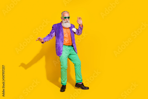 Full length photo of nice grandparent dancing enjoy celebrate weekend wear trendy colorful clothes isolated on yellow color background