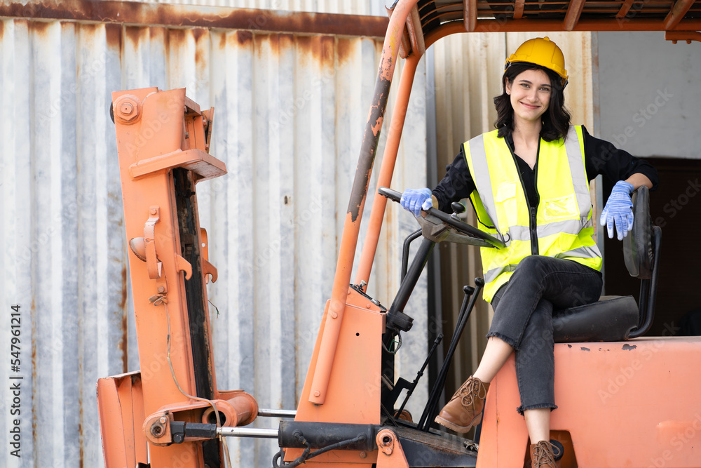 Foto de Female foreman wears hard hat driving forklift at shipping ...