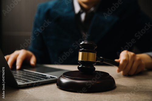 Business and lawyers discussing contract papers with brass scale on desk in office. Law, legal services, advice, justice and law concept picture with film grain effect