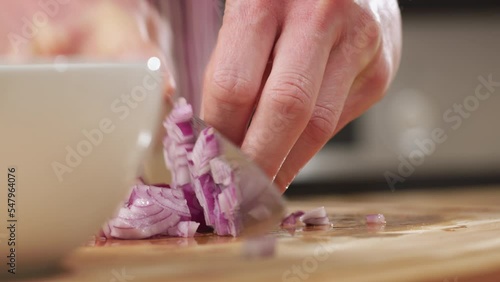 Home chef making salsa in the kitchen - chopping red onion. Closeup shot.