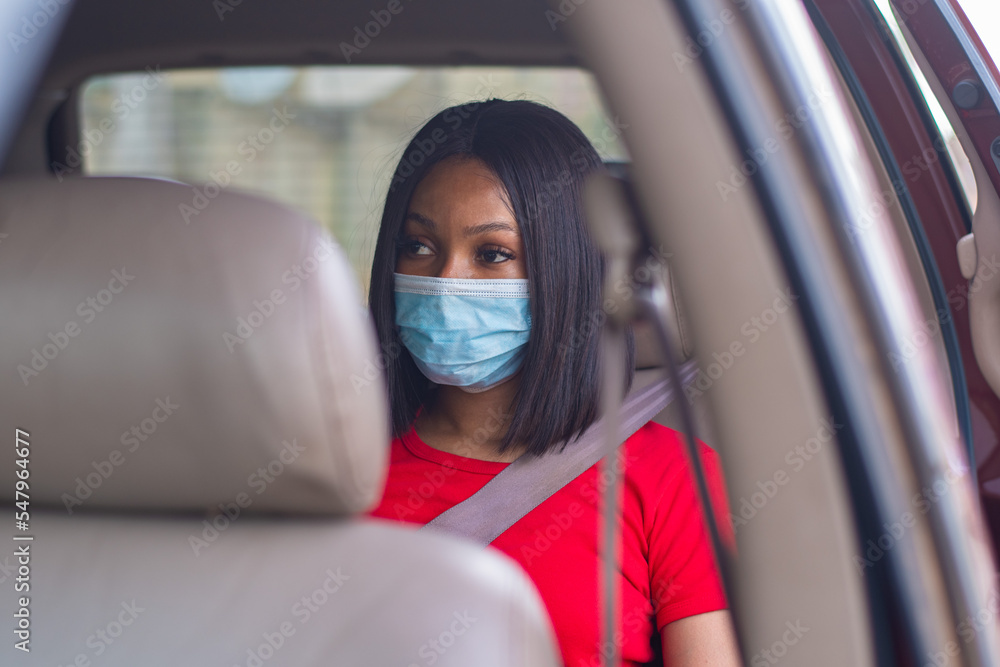 african lady with a face mask commuting in a taxi african lady with a face mask commuting in a taxi