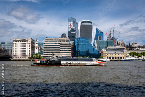 Cityscape of city of London over river Thames with Uberboat.