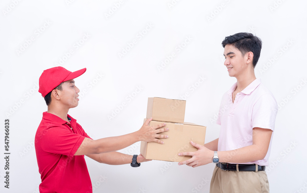 A customer in his 20s receives two parcels from a delivery man. An order delivered on time to a satisfied business man. A customer in his 20s receives two parcels from a delivery man. An order delivered on time to a satisfied business man.