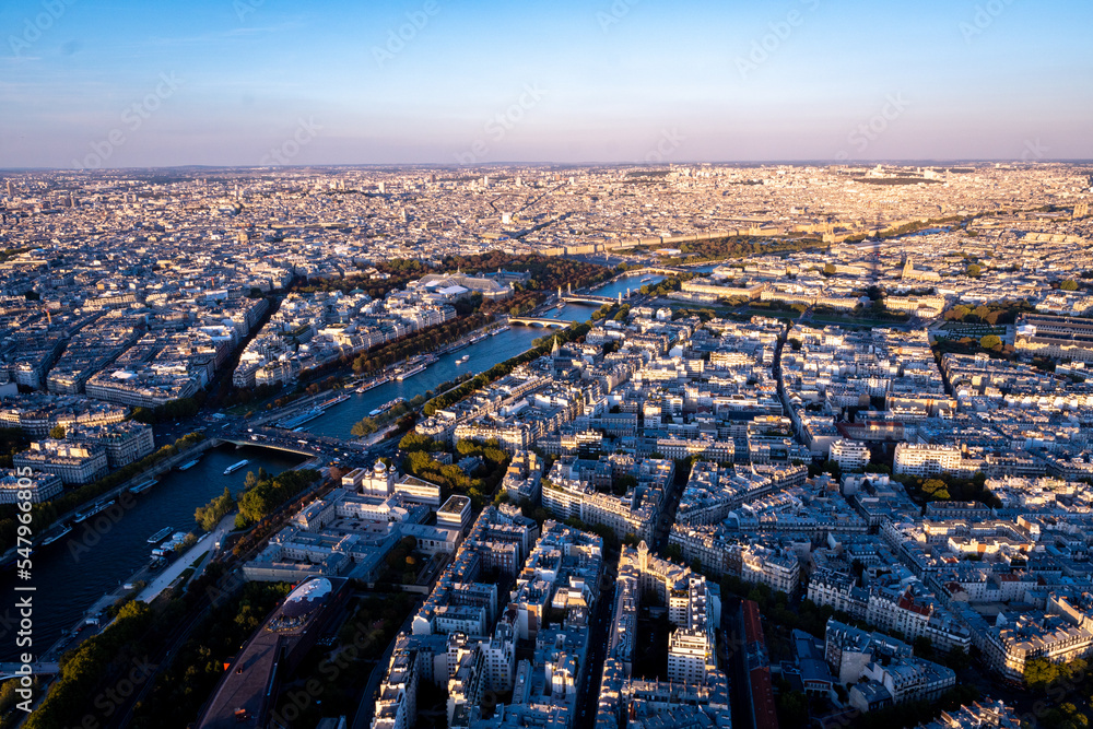 Photo of paris rooftops and Seine from Eiffel tower during spring sunset.