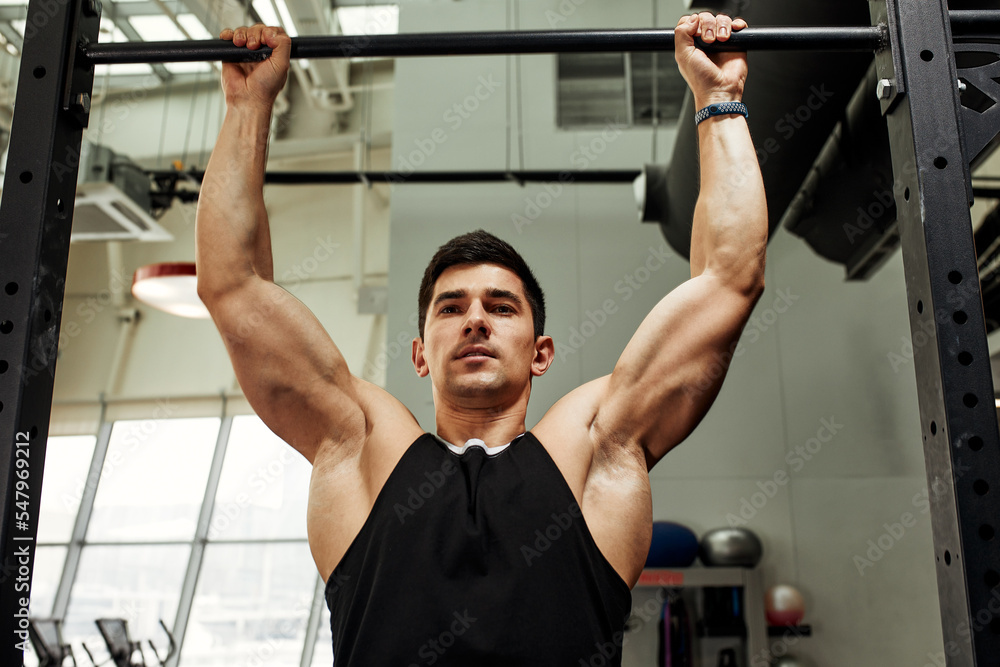 Naklejka premium work with own weight, the athlete does exercises on the uneven bars.