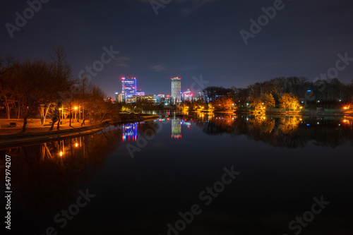 Obraz na płótnie Bukarest - Parklandschaft mit See bei Nacht mit modernen beleuchteten Bürogebäuden im Hintergrund w salonie