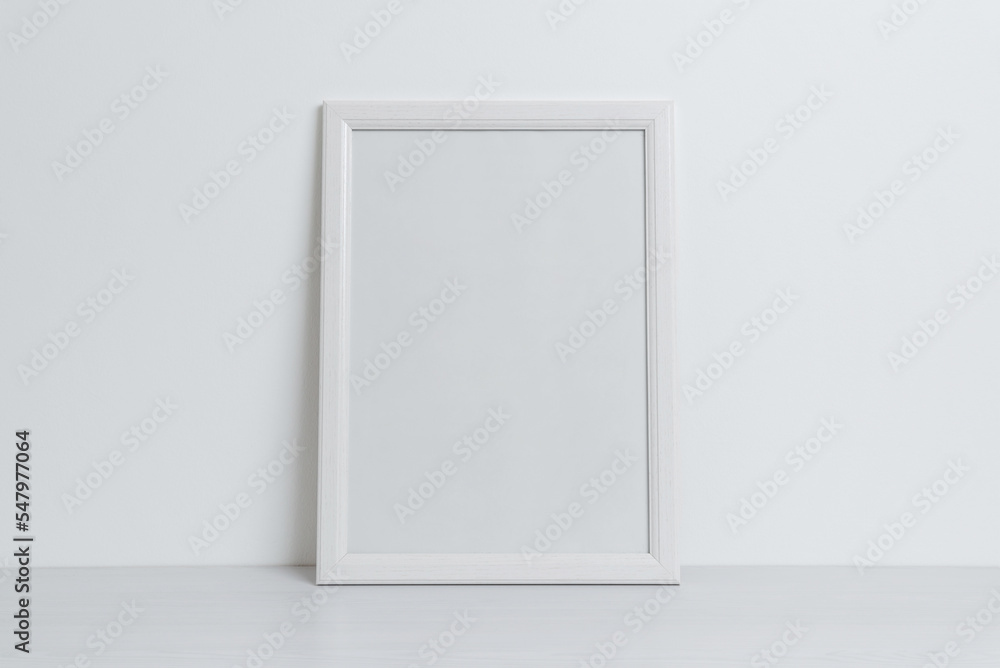 White picture frame mockup leaning against the wall. Clean, blank surface for art presentation White picture frame mockup leaning against the wall. Clean, blank surface for art presentation