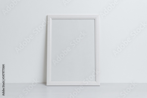White picture frame mockup leaning against the wall. Clean, blank surface for art presentation