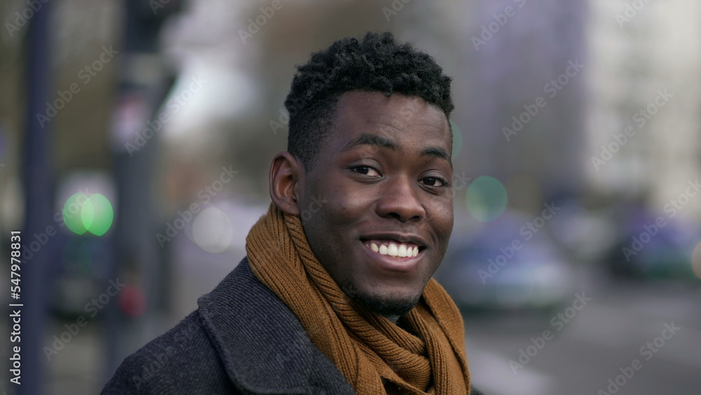 Happy black man smiling at camera standing outside in street looking at camera Happy black man smiling at camera standing outside in street looking at camera