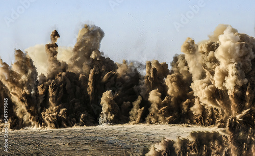 Dust clouds and rock particles during detonator blast in the Arabian desert 