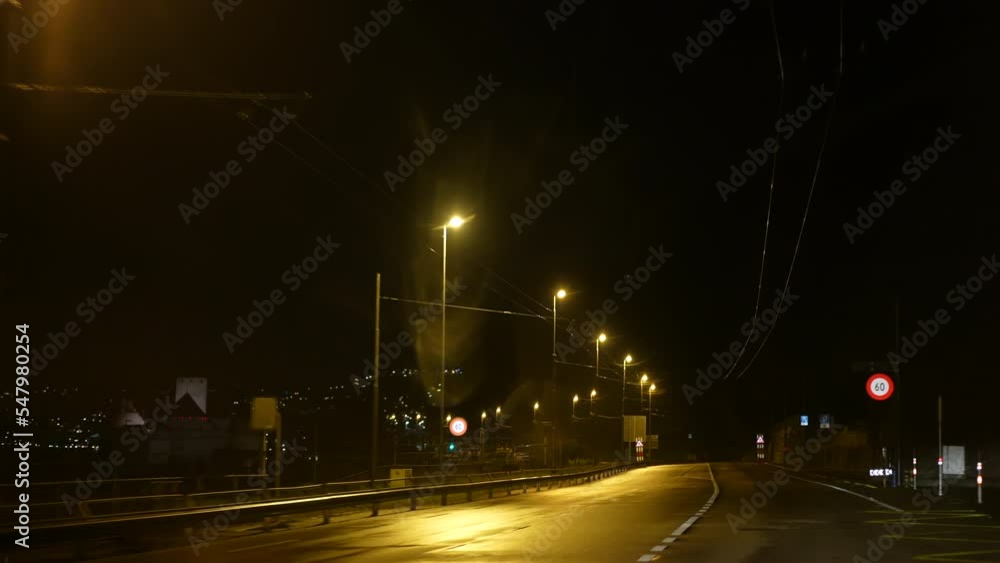 Passenger inside car vehicle looking at lamp posts passing by at night. glowing light in the dark Passenger inside car vehicle looking at lamp posts passing by at night. glowing light in the dark