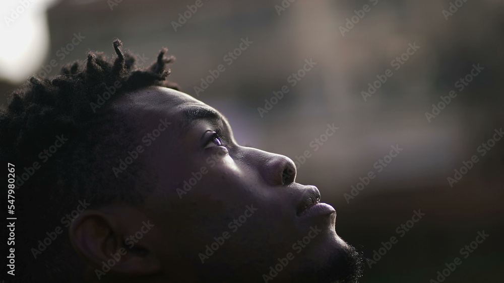 Hopeful black African man close-up face joyful emotion Hopeful black African man close-up face joyful emotion