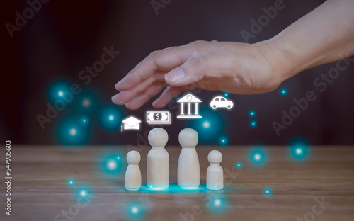 The man hands protect over wooden peg dolls family. Concept planning, saving money. Quality family, hedging, stability in life, health care and insurance, mental health, international day of families.