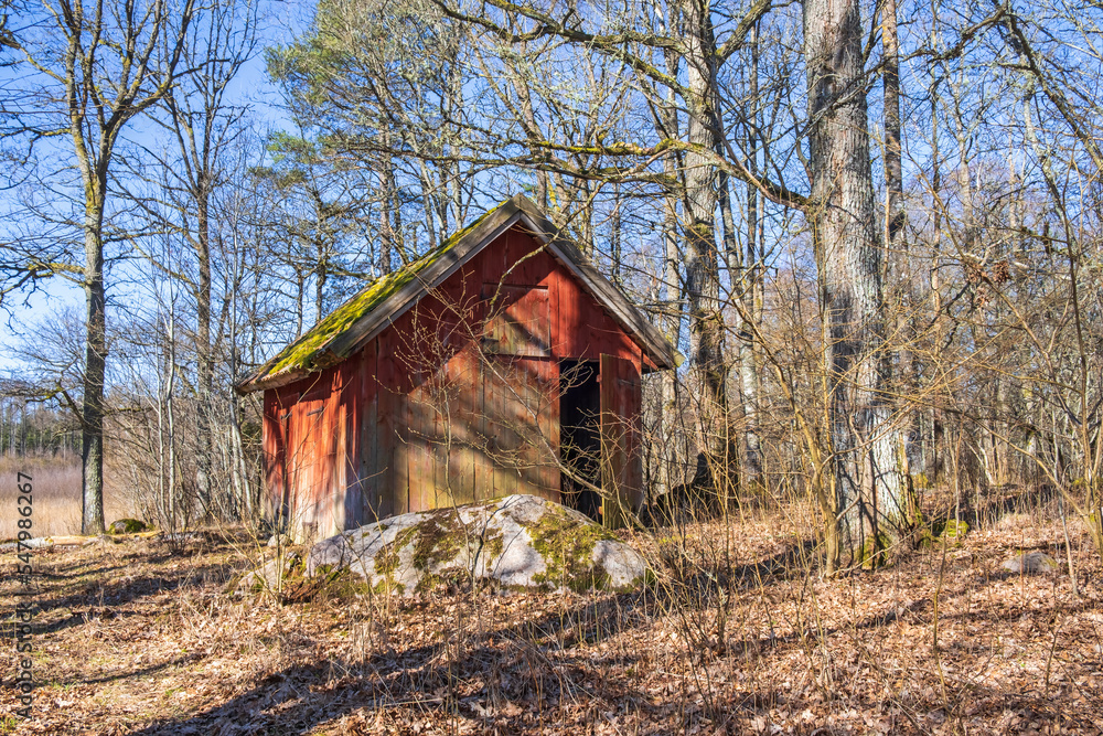 Old red wooden shed in the forest Old red wooden shed in the forest