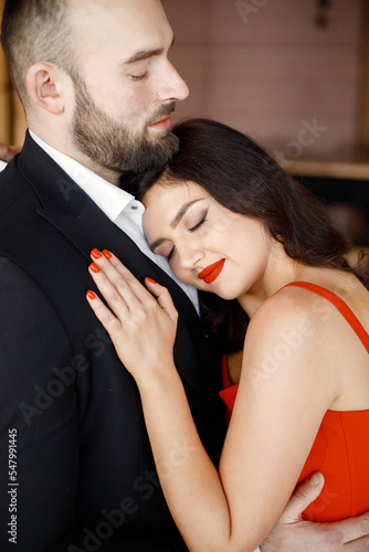 Portrait of romantic couple standing in restaurant on a date and hugging