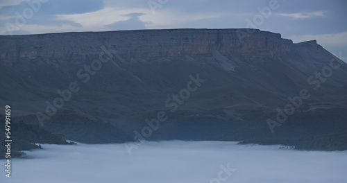 Wallpaper Mural Mountain evening landscape with low clouds in the valley and a steep cliff in the background, panorama of the evening mountains Torontodigital.ca