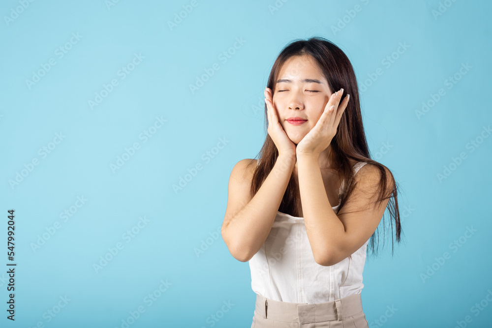Beauty and Skin care. Beautiful woman model smiling with natural makeup and healthy face, Asian female with beauty face touching healthy facial skin studio shot isolated on blue background Beauty and Skin care. Beautiful woman model smiling with natural makeup and healthy face, Asian female with beauty face touching healthy facial skin studio shot isolated on blue background