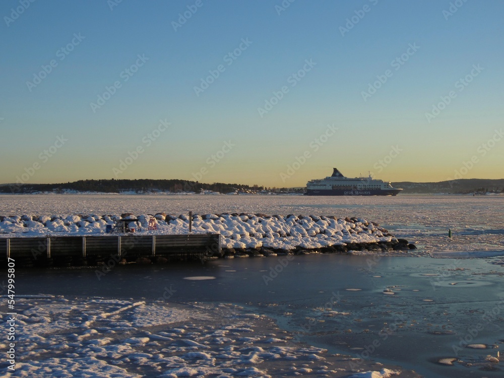 A large ferry in the partially frozen Oslofjord on a beautiful cold sunny day with blue sky A large ferry in the partially frozen Oslofjord on a beautiful cold sunny day with blue sky