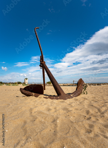 Großer Anker am Strand mit blauem Himmel